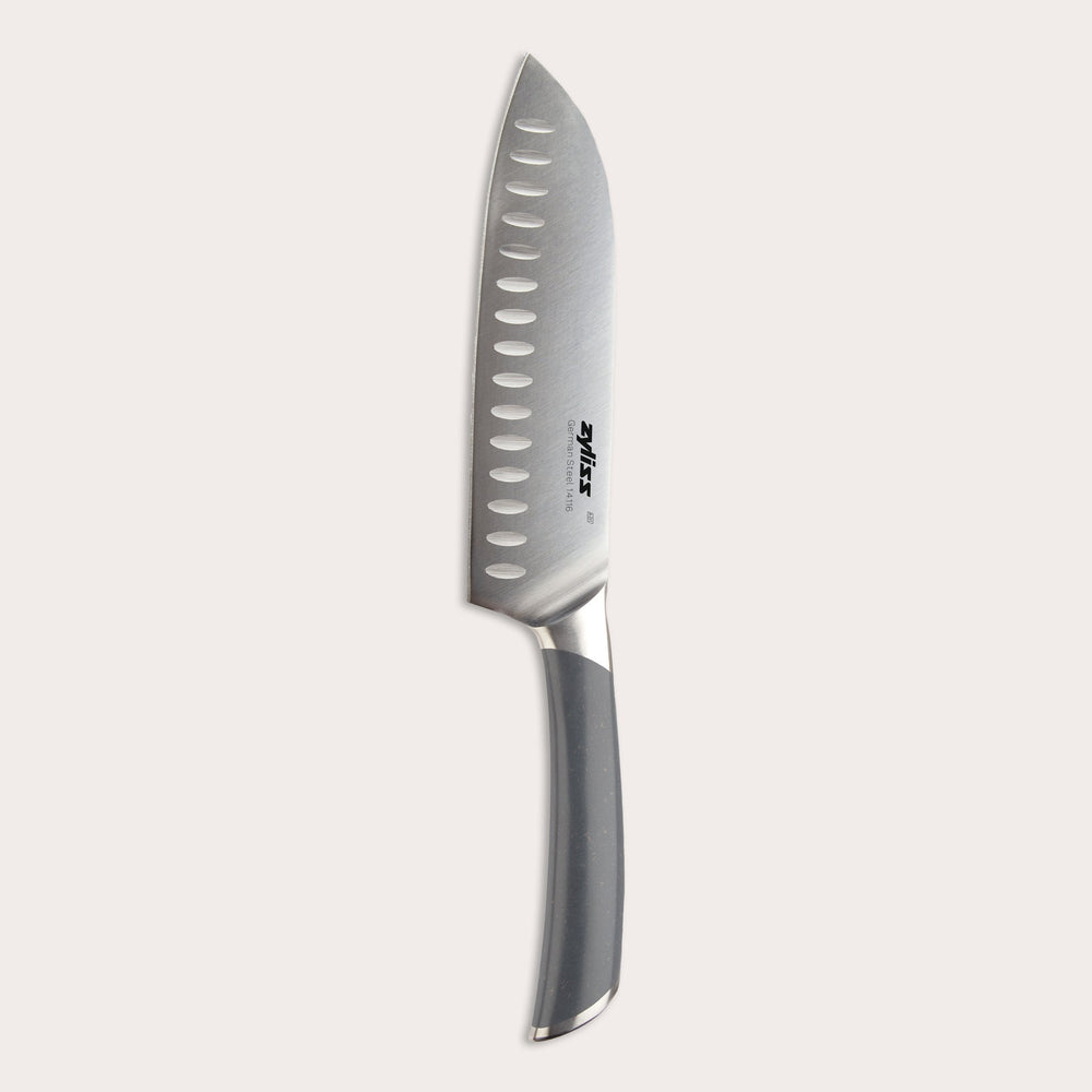 The Zyliss Comfort Pro Santoku Knife 18.5cm/7" features German stainless steel, an ergonomic gray handle, and oval blade indentations, shown on a plain light background.