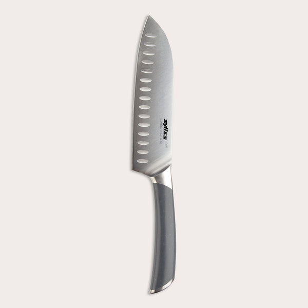 The Zyliss Comfort Pro Santoku Knife 18.5cm/7" features German stainless steel, an ergonomic gray handle, and oval blade indentations, shown on a plain light background.