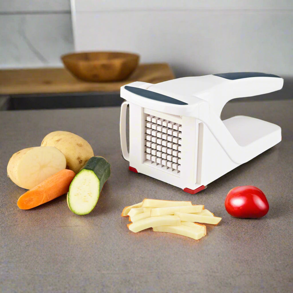 The Zyliss Potato & Vegetable Chipper is a white and gray handheld tool with sharp stainless steel blades, designed to easily slice or dice potatoes and other foods; shown here on a neutral background. 