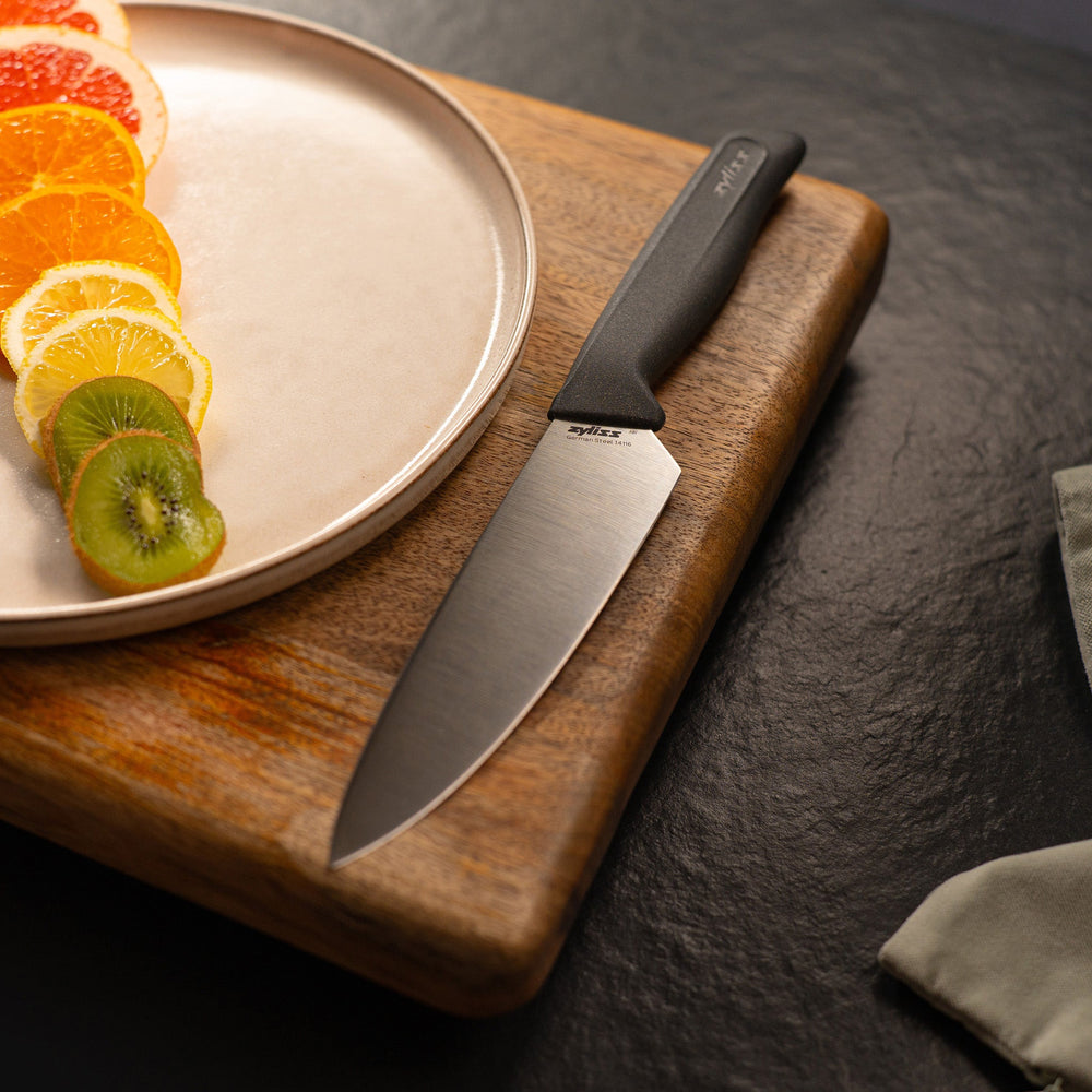 #15cm/6" The Zyliss Chef Knife 15cm / 6 features a silver blade and a sustainable black ergonomic handle, displayed against a plain white background.