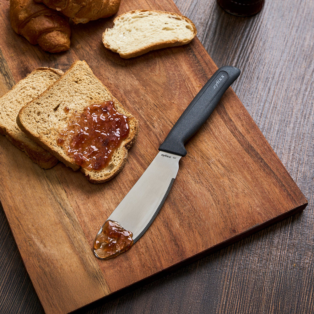 The Zyliss Spreading Knife 12cm/5" features a wide, rounded stainless steel blade and an ergonomic black handle, shown on a plain white background.