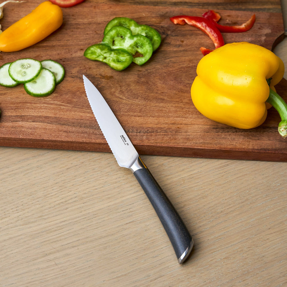 The Zyliss Comfort Pro Serrated Paring Knife 11.5cm features a German stainless steel silver blade and ergonomic gray handle, displayed against a plain light background.