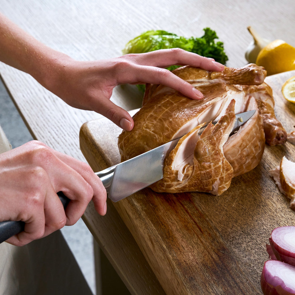 The Zyliss Comfort Pro Carving Knife 20cm/8" features a German stainless steel silver blade and an ergonomic gray and silver handle, shown vertically on a light background.