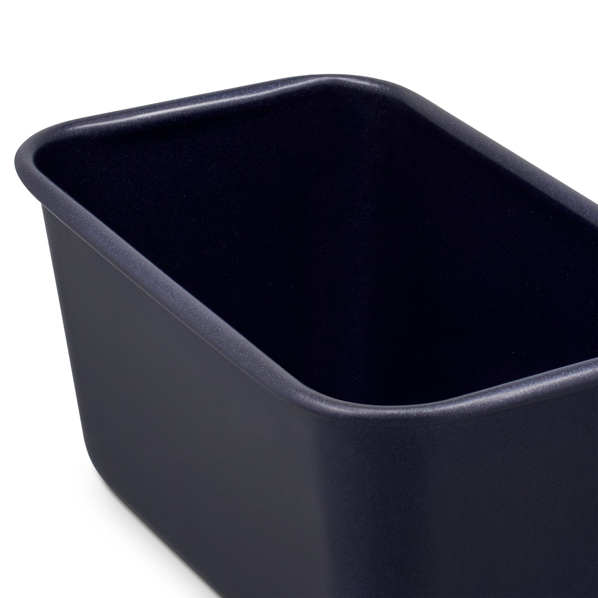 A close-up of a rectangular, deep, dark-colored loaf pan with rounded corners, set against a white background.