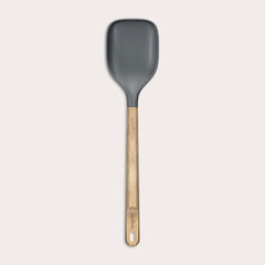 The Zyliss Oak Wood Spoon Large features a gray silicone head, an oak wood handle with a hanging hole, and is shown on a plain white background—a versatile utensil for home cooks.