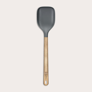 The Zyliss Oak Wood Spoon Large features a gray silicone head, an oak wood handle with a hanging hole, and is shown on a plain white background—a versatile utensil for home cooks.