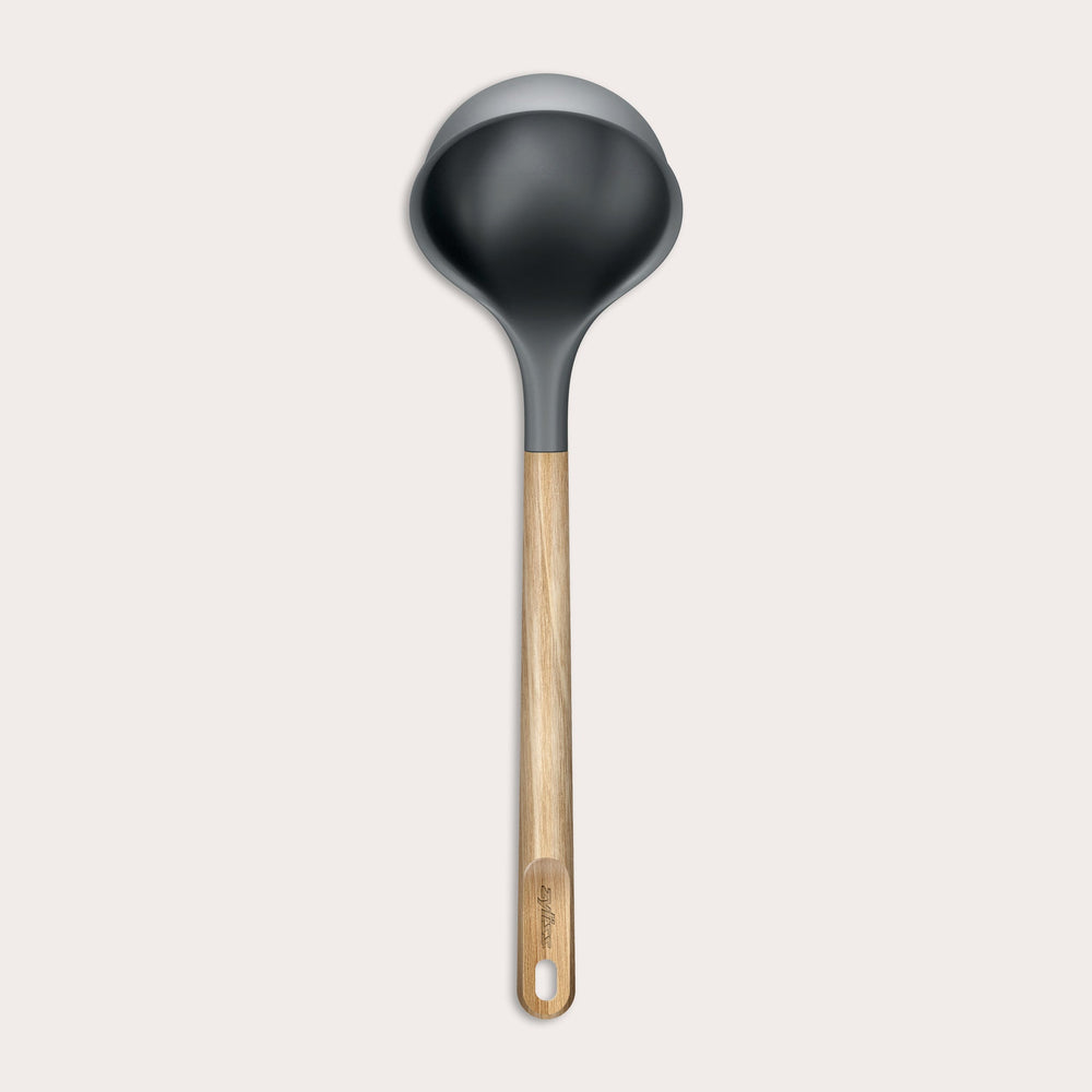 The Zyliss Oak Wood Ladle Large is black with a gray rim and a long oak handle featuring a hanging hole, displayed on a plain light background.