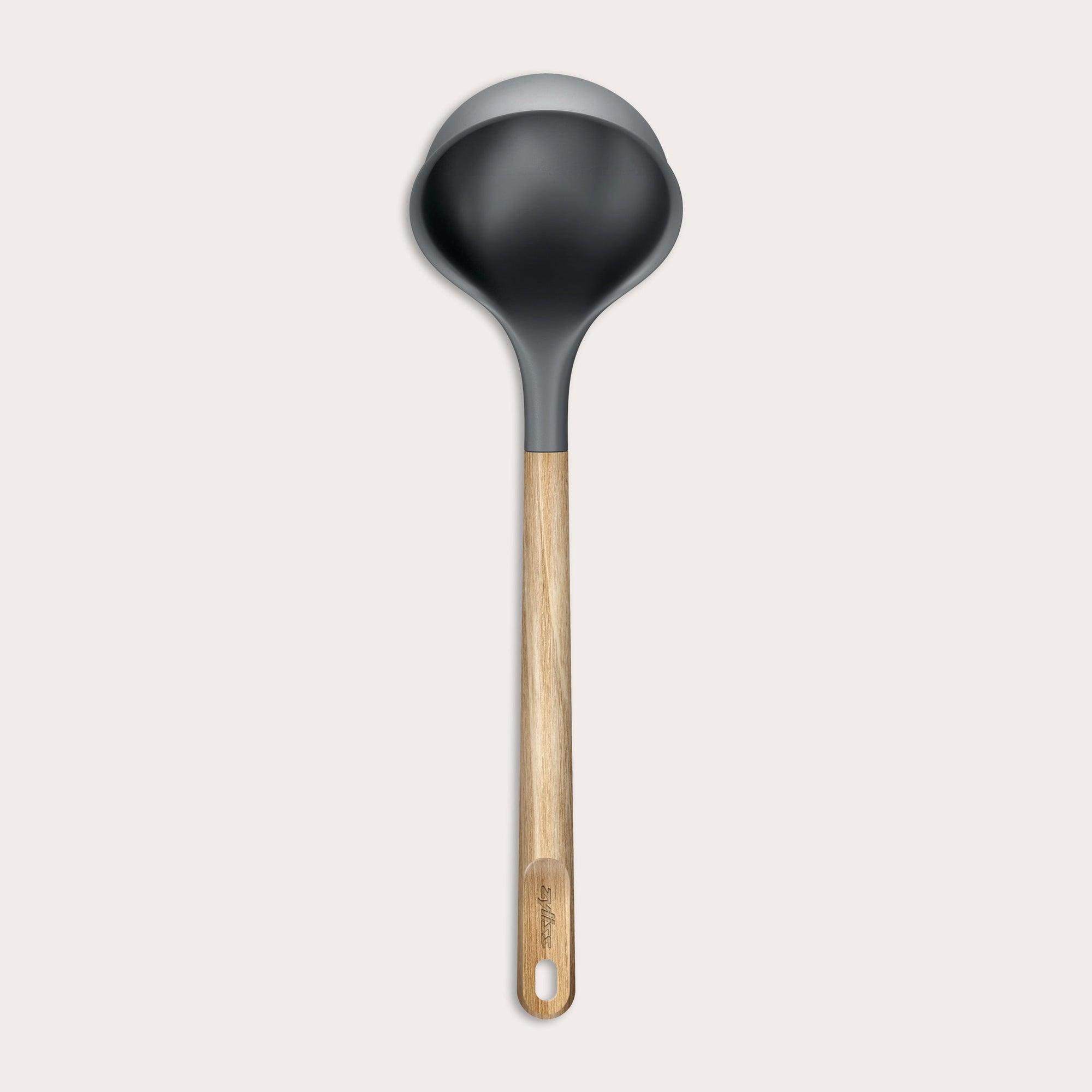 The Zyliss Oak Wood Ladle Large is black with a gray rim and a long oak handle featuring a hanging hole, displayed on a plain light background.