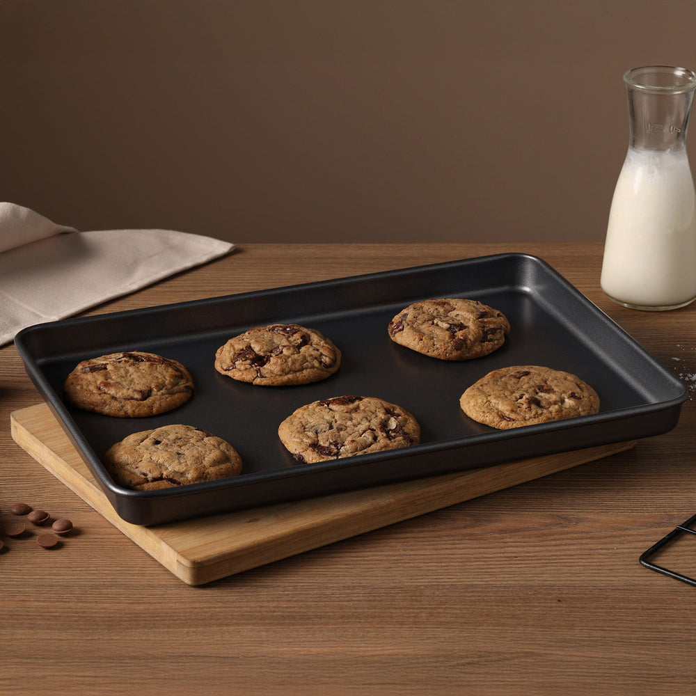 The Zyliss Non-Stick Baking Tray is a black, rectangular carbon steel pan with slightly raised edges for even heat distribution, shown against a plain white background.