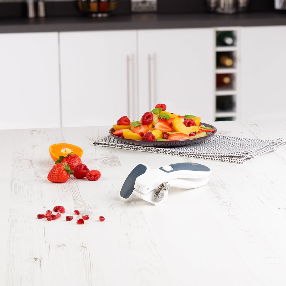 The Zyliss Lock & Lift Can Opener, shown on a plain light background, features white and dark gray colors, a large ergonomic handle, locking mechanism, and rotating cutting wheel. 