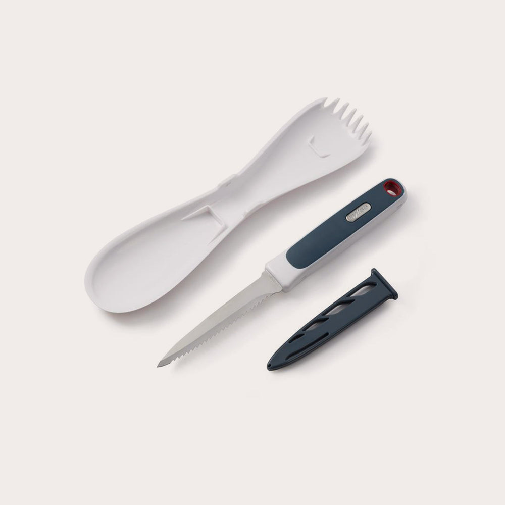 The Zyliss 3 In 1 Pumpkin & Squash Scoop & Knife set features a white plastic spork, spoon, serrated knife with black handle—ideal for pumpkin carving—and a black knife sheath, all arranged on a light background. 