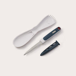 The Zyliss 3 In 1 Pumpkin & Squash Scoop & Knife set features a white plastic spork, spoon, serrated knife with black handle—ideal for pumpkin carving—and a black knife sheath, all arranged on a light background. 
