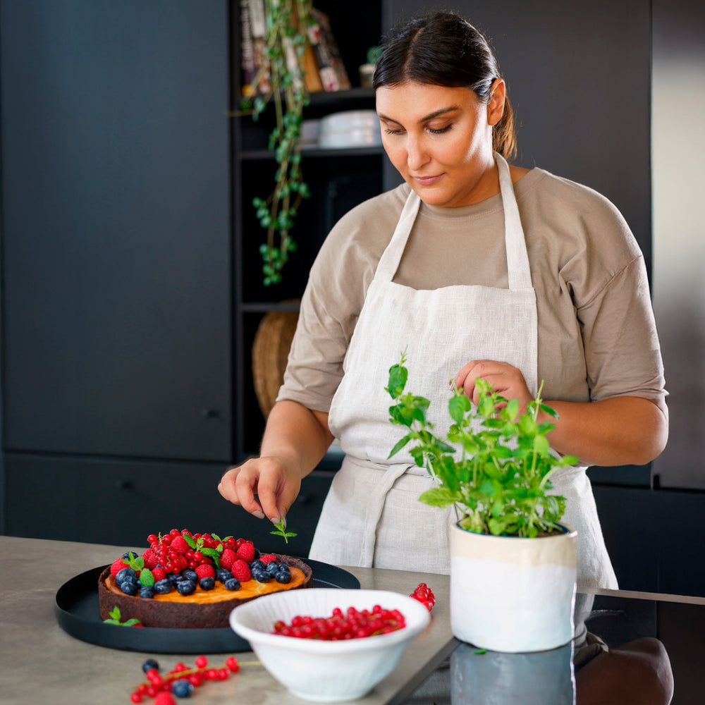 The Zyliss Flat Whisk Silicone features a black, heat-resistant silicone design with a long handle and looped wires, displayed on a plain light background. 